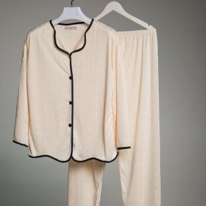 Cream colored pajamas with black trim hanging